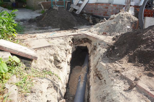 Digging a trench for the main drain pipe, sewer line to a sewer or septic tank. Sewer line replacement or repair