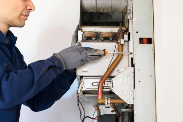 Smiling Technician Repairing an Hot-Water Heater